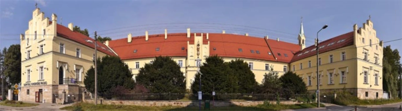 Budynek siedziby szpitala z beżową elewacją i czerwonym dachem
